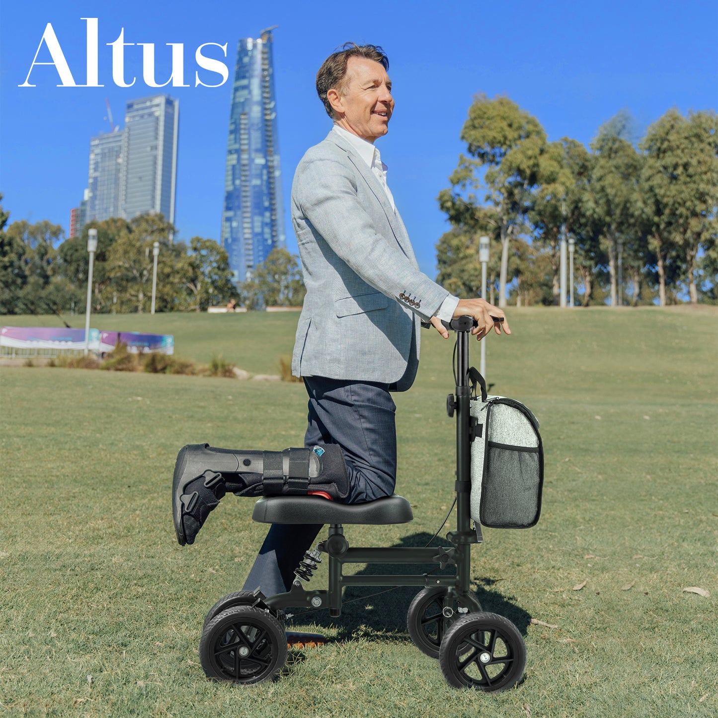 Man using a knee scooter in an outdoor setting with tall buildings in the background