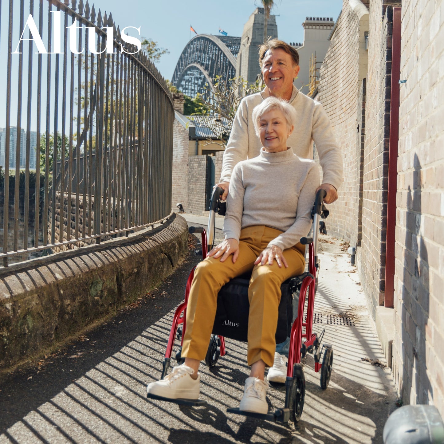 Woman pushing another woman in a wheelchair with a scenic background