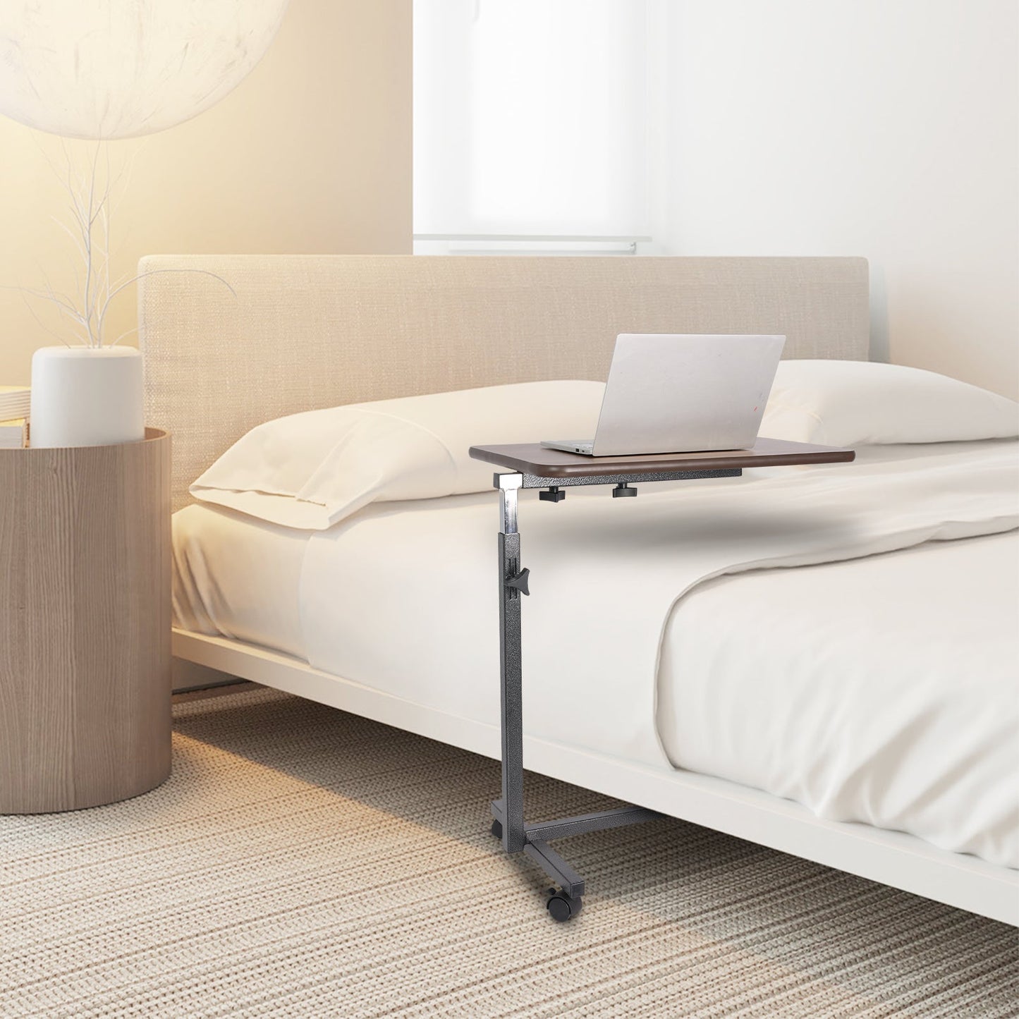 Altus adjustable overbed table in a bedroom, used as a laptop stand, illustrating its adaptability for various room styles.