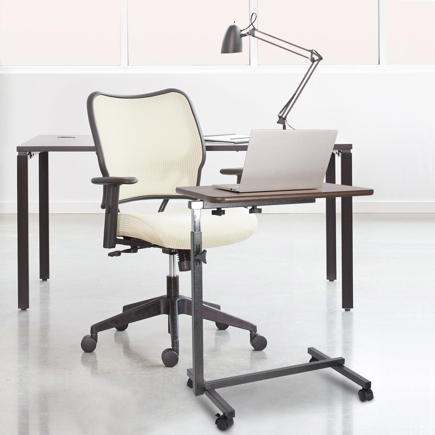 Altus overbed table as a mobile workstation in an office, offering a convenient adjustable desk solution for modern workspaces.