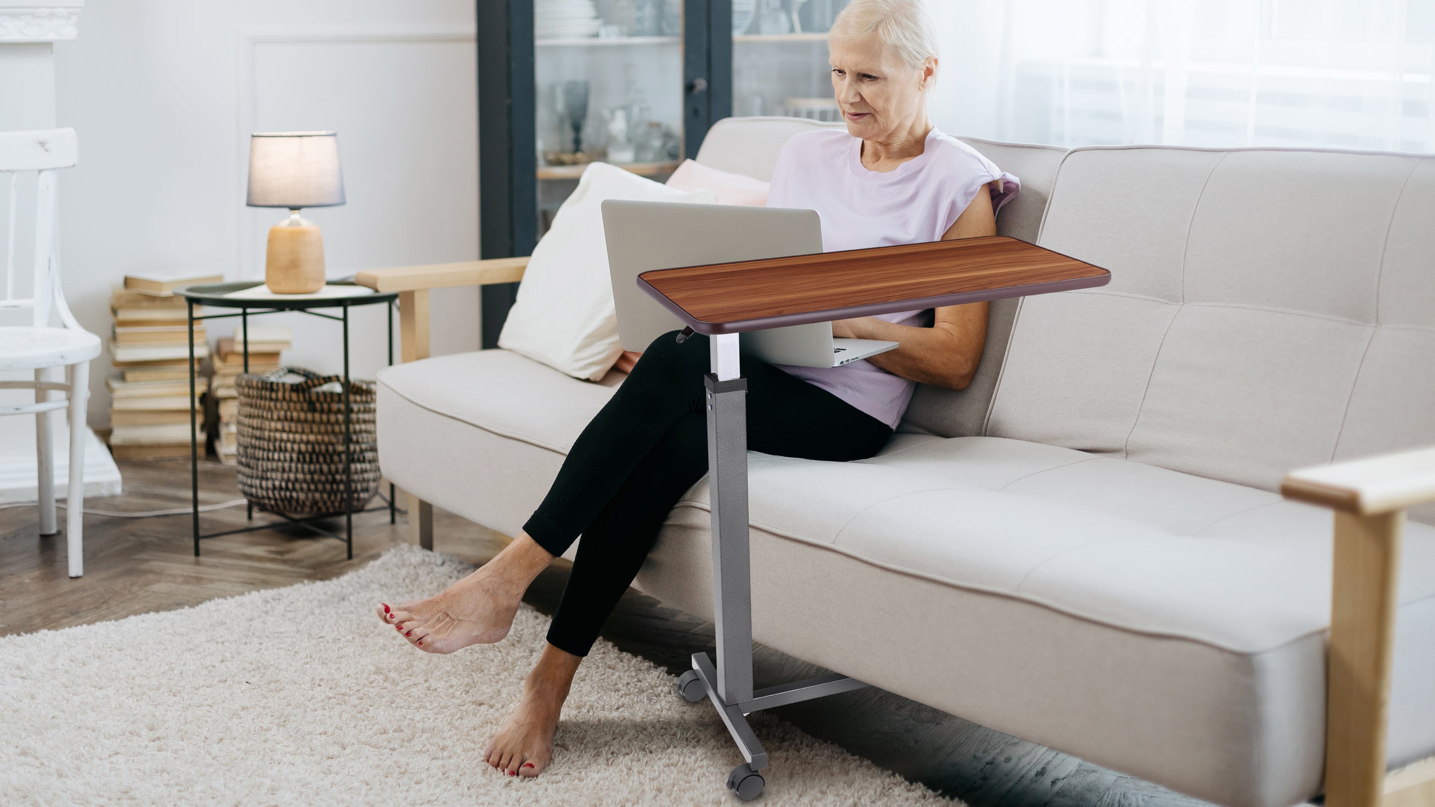 This overbed table offers comfort and convenience for seniors and home users alike. With a height-adjustable frame and smooth-rolling wheels, it easily slides beside a bed or sofa, supporting laptops, meals, or books — wherever needed.