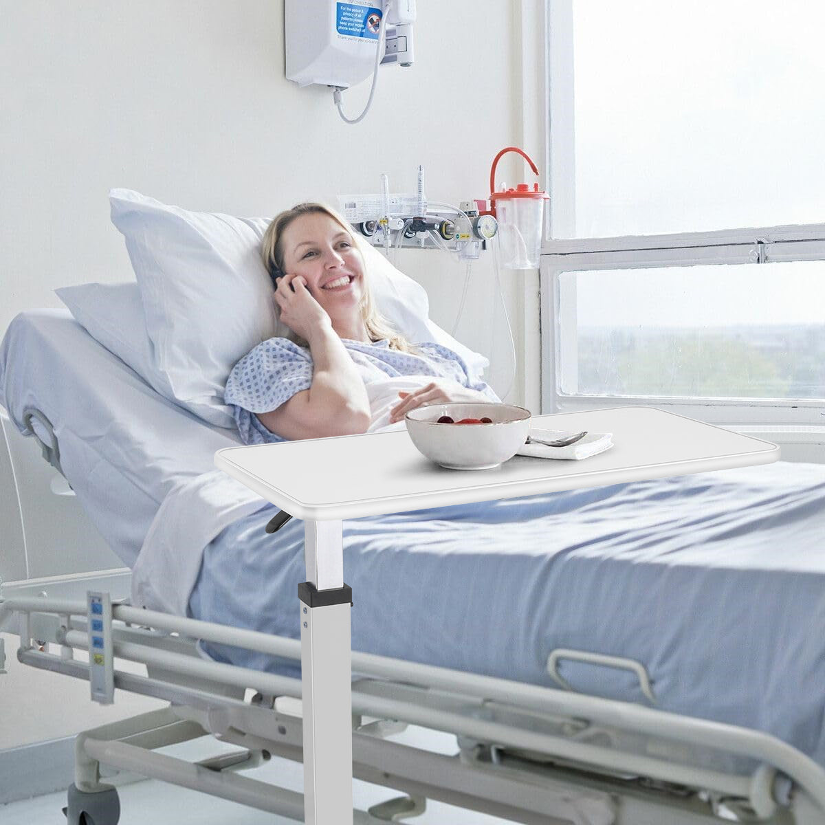 Usage in a Hospital Bed:The overbed table is an essential tool for enhancing the comfort and convenience of patients during recovery. In this scene, a young woman lies in her hospital bed, utilizing the table to enjoy a healthy meal.