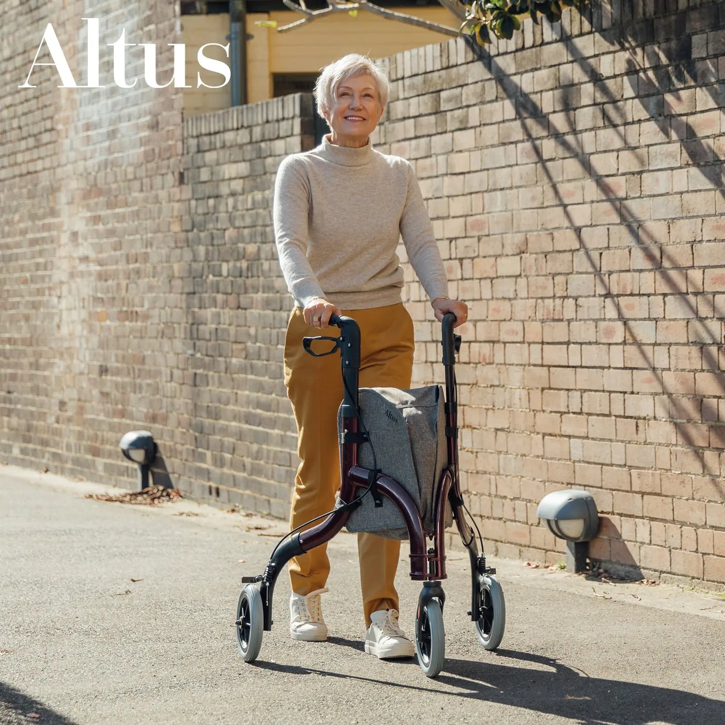 An elderly man using the Altus Rollator on a sidewalk, demonstrating its practical application in an urban setting. The rollator is shown in action, highlighting its ease of use and the support it provides to the user. The image underscores the rollator’s suitability for daily activities and mobility enhancement.