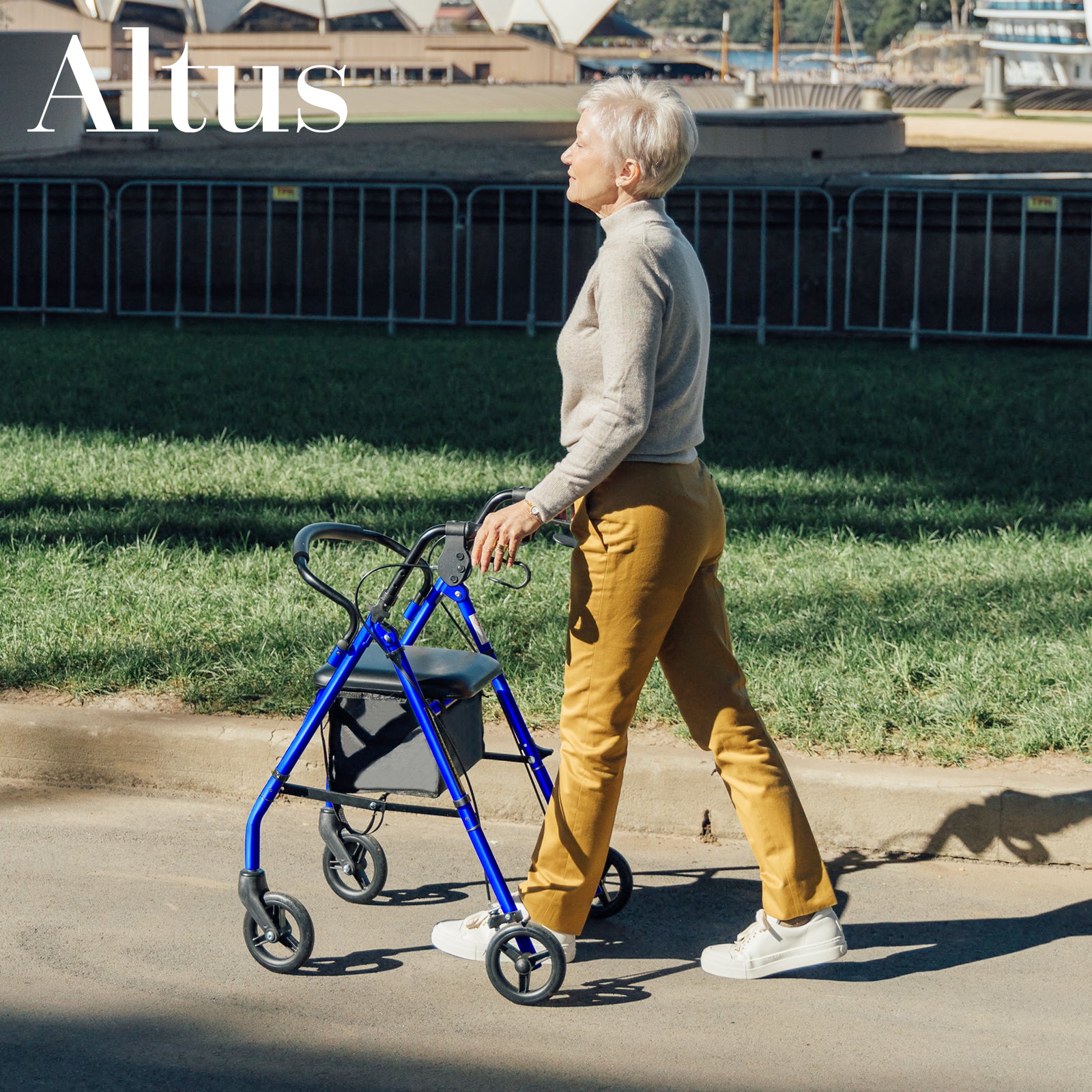 Woman walking with a blue walker on a sidewalk