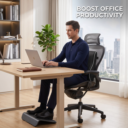 A man in a navy long-sleeve shirt sits in a black mesh ergonomic office chair at a light wood desk, using a laptop in a bright home office. A footrest is visible beneath him, and the text 'BOOST OFFICE PRODUCTIVITY' appears in the top right.