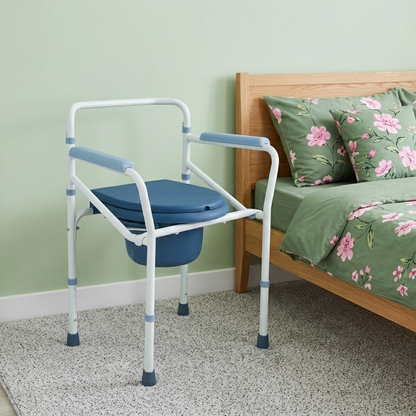commode chair next to a bed with floral bedding.