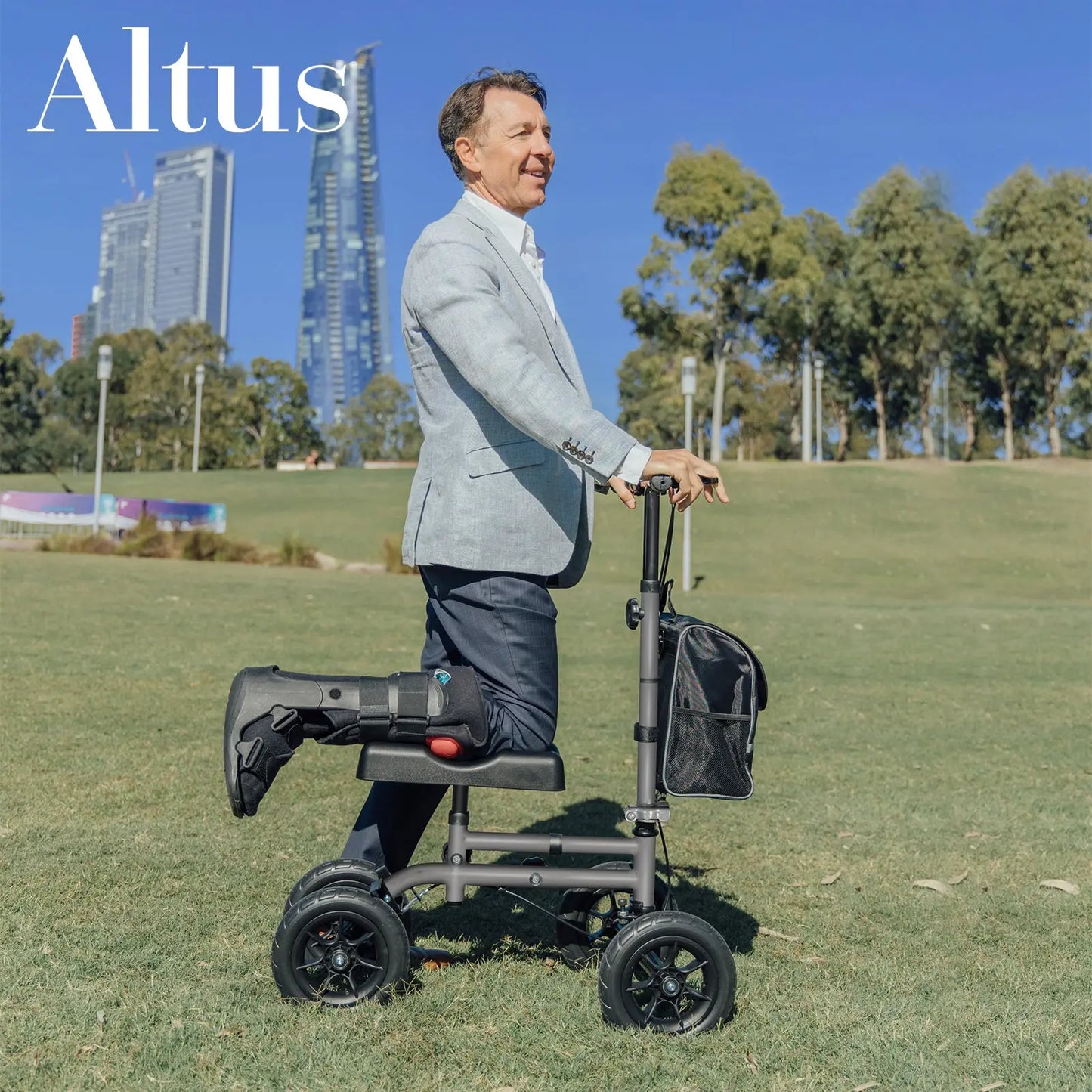 An image of a man using the knee walker in an outdoor setting, dressed in a smart casual outfit. The walker is portrayed as a practical mobility aid for active professionals who need to maintain mobility during recovery. The background of a city park reinforces the knee walker’s suitability for diverse environments and lifestyles.