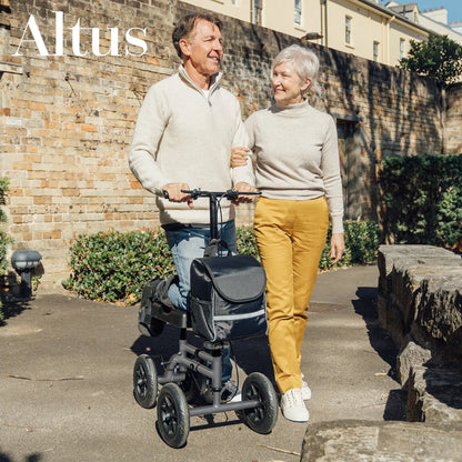 This image depicts an elderly couple enjoying a walk in the park, with the man using the knee walker for support. The knee walker is shown to be a reliable mobility aid, helping users maintain an active lifestyle despite injuries. The couple's casual attire and the sunny, outdoor setting highlight the knee walker's versatility and ease of use 