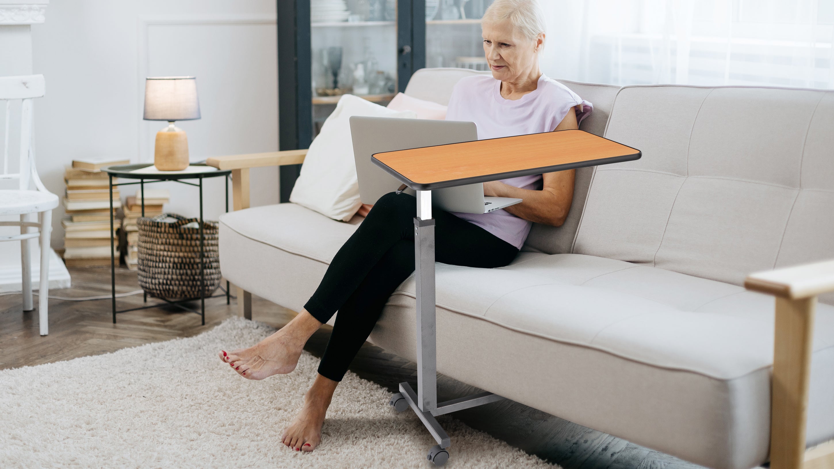 This overbed table offers comfort and convenience for seniors and home users alike. With a height-adjustable frame and smooth-rolling wheels, it easily slides beside a bed or sofa, supporting laptops, meals, or books — wherever needed.