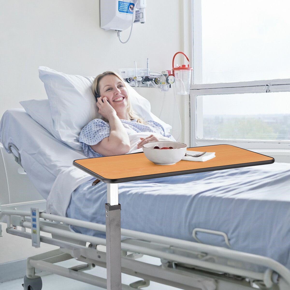 Overbed table in use by a patient in a hospital bed, providing a convenient surface for meals and activities.