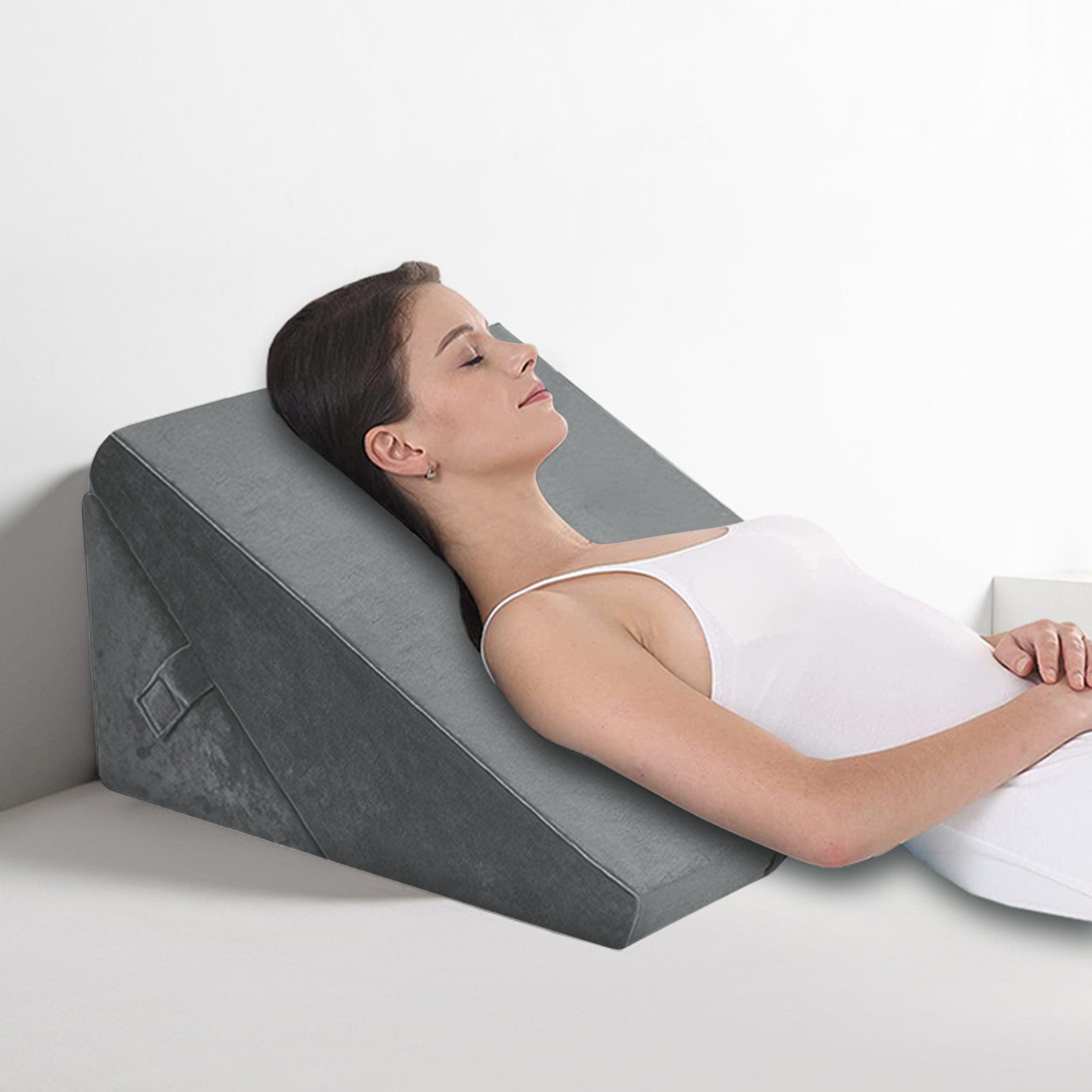 Woman using a wedge-shaped pillow on a bed