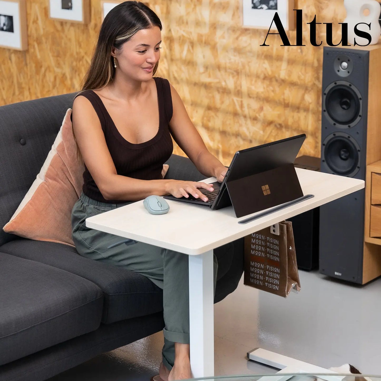 Casual work setting with a woman using a laptop on a minimalist white adjustable desk, showcasing the desk's usability in home office environments