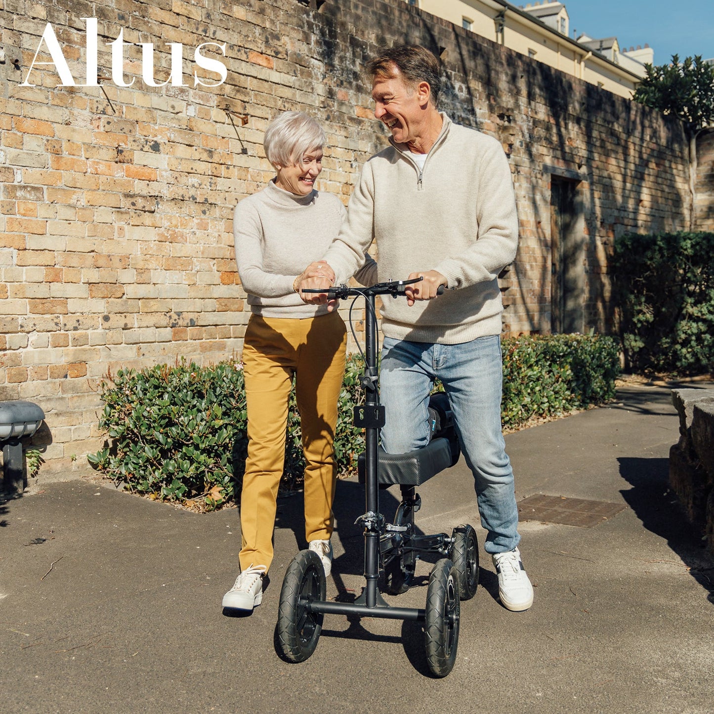 "Older couple enjoying a walk with the Altus Knee Scooter, showcasing ease of use and mobility."