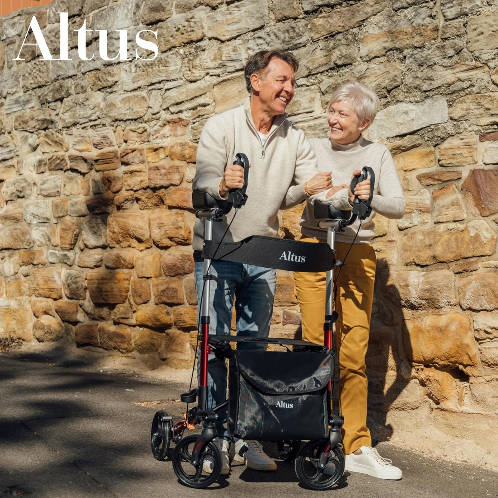 Two people standing with Altus rollators against a stone wall.