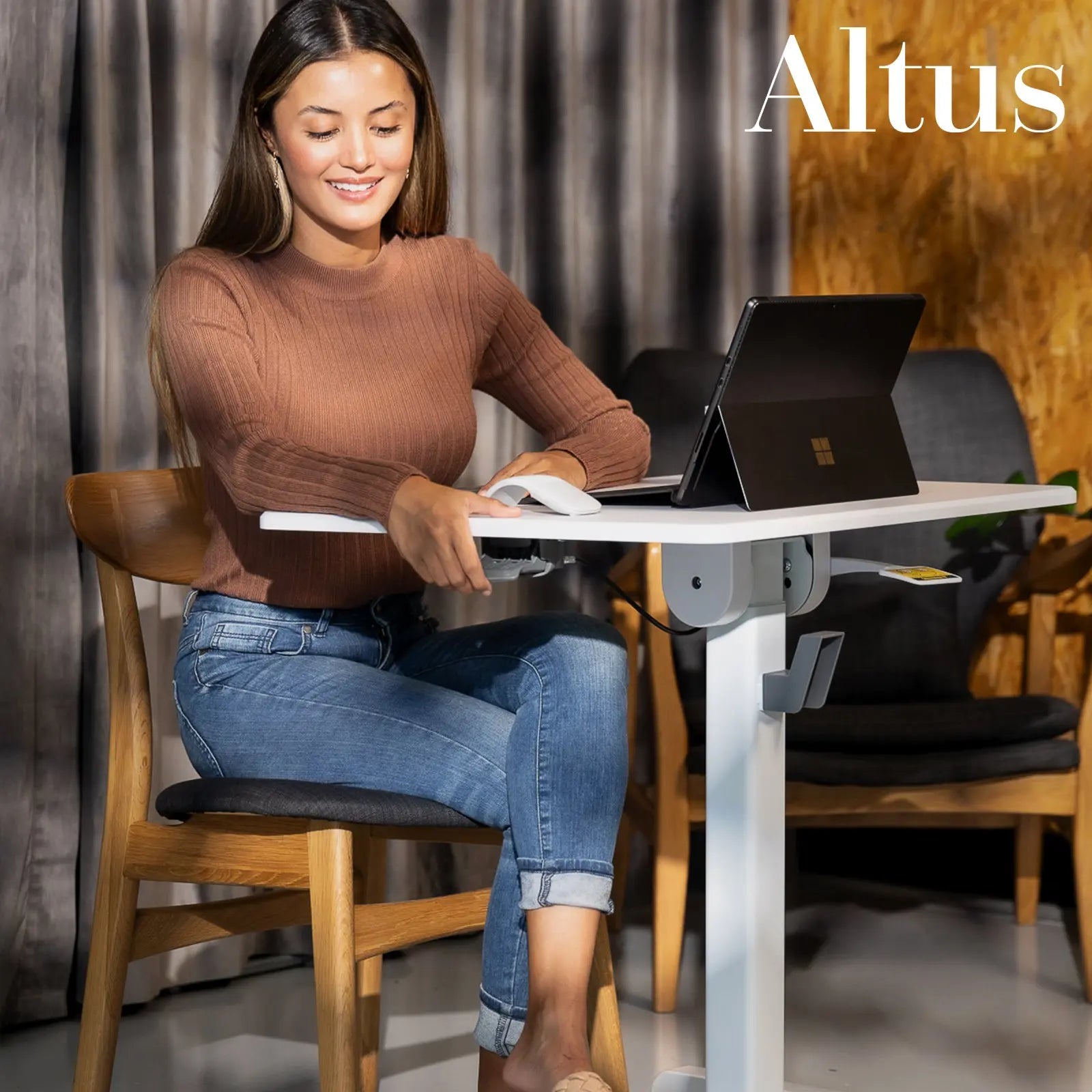 A woman enjoys using a laptop at a mobile desk in a cozy home environment, showcasing the desk's usability in small spaces.