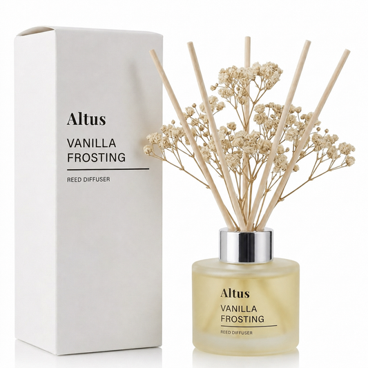 Altus Vanilla Frosting reed diffuser bottle with dried baby's breath stems and reeds, shown next to its white packaging box on a white background.