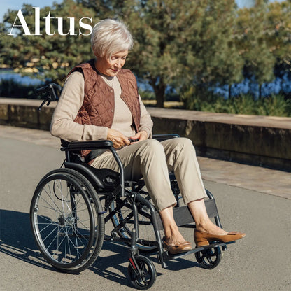 A senior woman sitting comfortably in the Altus 20-Inch Wheelchair in Black. This wheelchair features a durable frame, ergonomic design, and easy-to-use footrests, providing excellent support and mobility for users.