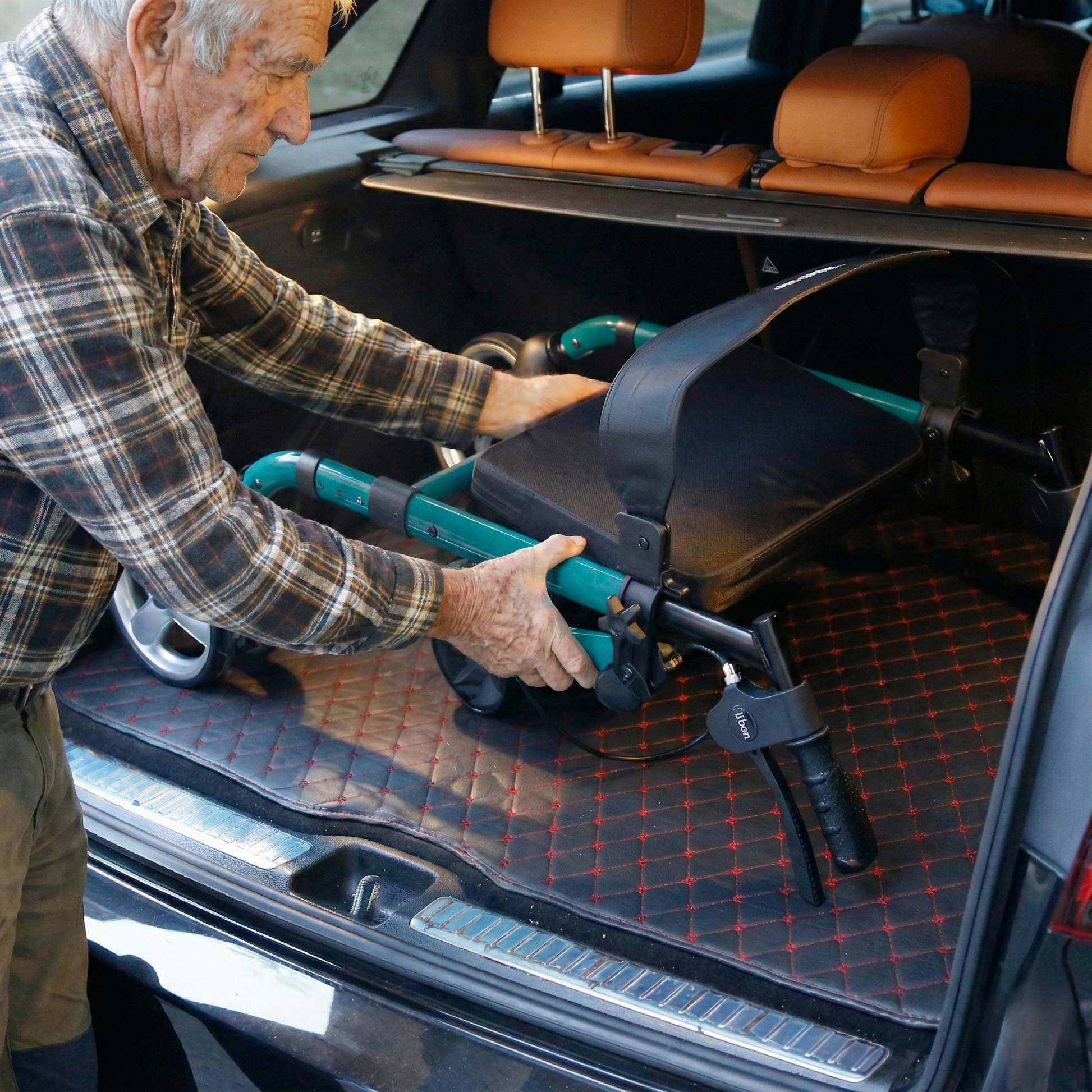Man loading a portable wheelchair into the back of a car