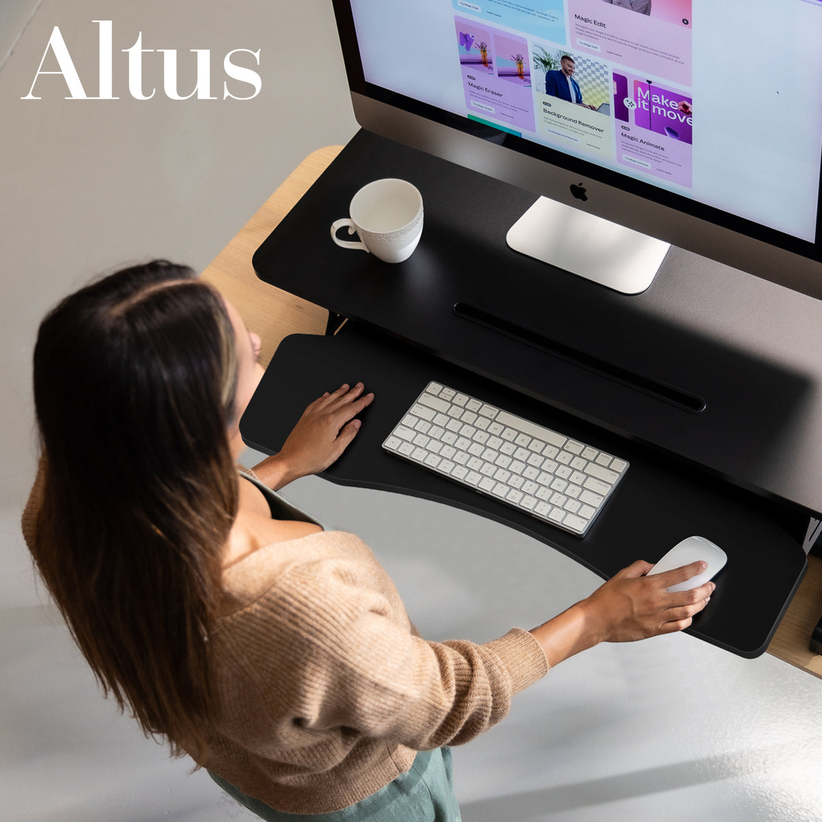 Person using a computer at a standing desk with 'Altus' branding.