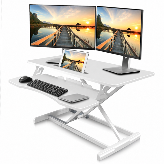 A white adjustable standing desk with a keyboard tray, shown with a dual monitor, tablet, mouse, and keyboard on a clean white background.