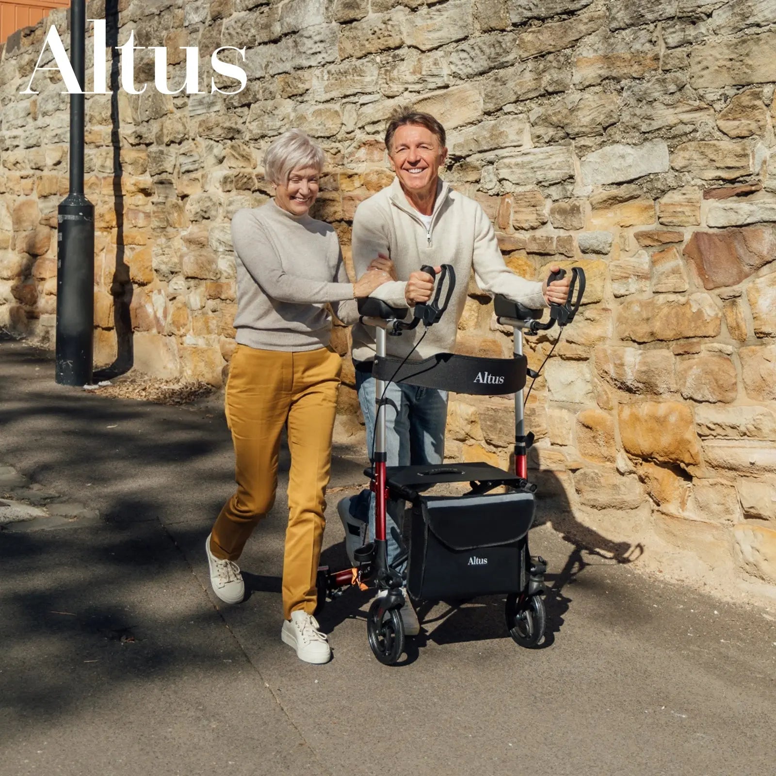 An elderly couple enjoying a walk with the Altus Ergonomic Upright Walker with Seat. The walker features a sturdy frame, ergonomic hand grips, and a convenient storage bag, ideal for maintaining mobility and independence.