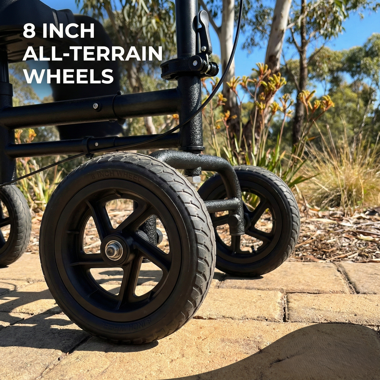 Black all-terrain wheelchair with 8-inch wheels on a paved path with natural background