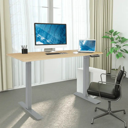 A realistic office setup with a motorized adjustable desk featuring a wooden top, placed near a window with curtains, supporting two computers and various desk accessories.